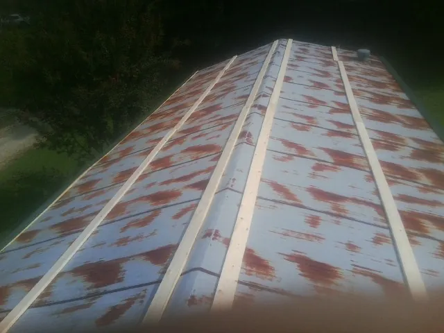 Rusted metal roof panels with new wood purlins before replacement — Storm Damage Roof Repair in Milburn by Roofing Brothers