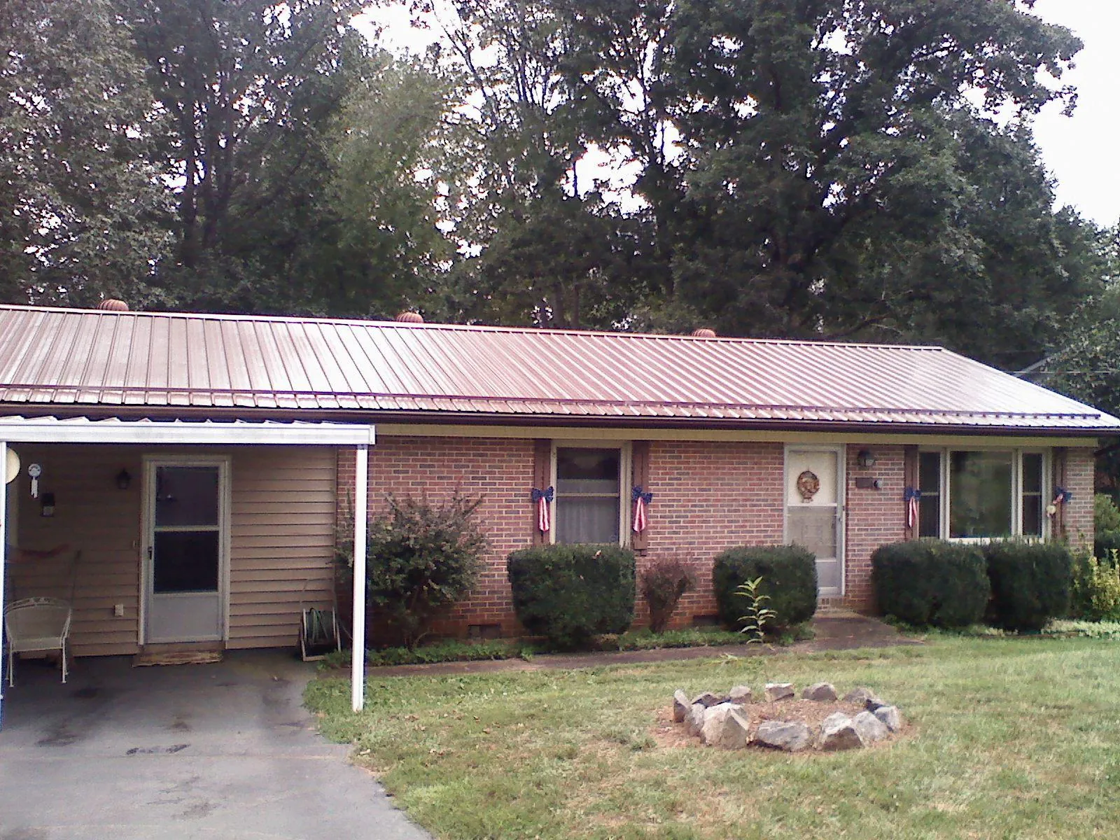Bronze metal roof and carport on a brick ranch home — Roof Repair work by our crew in Milburn