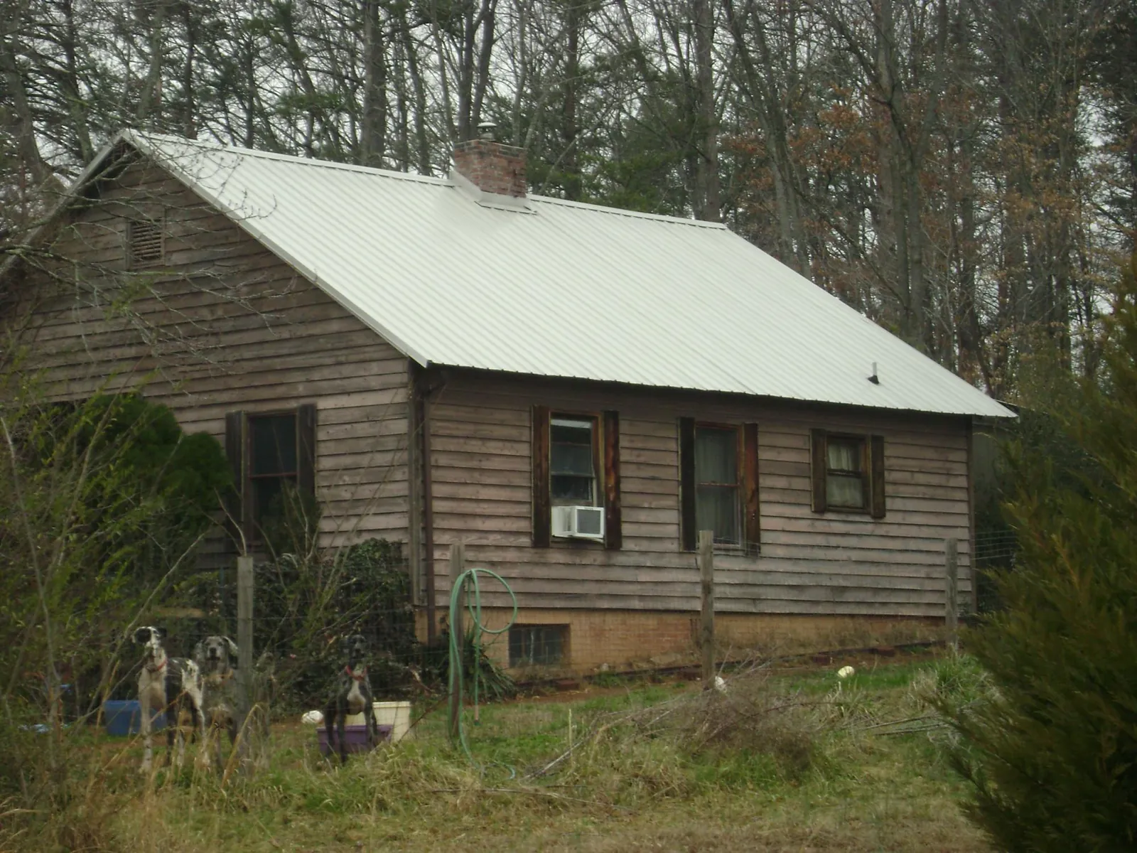 White metal roof on an old wood sided farmhouse, from a Metal Roof Installation job in Milburn